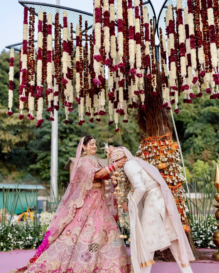 A couple at their Vedic wedding with pastel floral decor